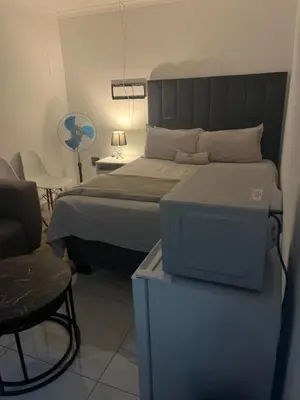 a bedroom with a bed and a table with a chair at Mohwelere Guest House in Pretoria