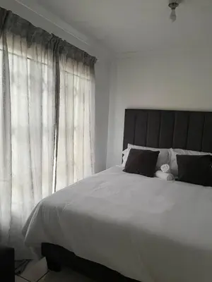 a bedroom with a large bed and a window at Mohwelere Guest House in Pretoria