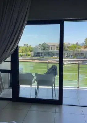 a table and chairs in a room with a window at Lake Villa Hartebees in Hartbeespoort
