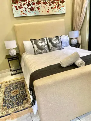 a bedroom with a bed with two faces on the pillows at Lake Villa Hartebees in Hartbeespoort