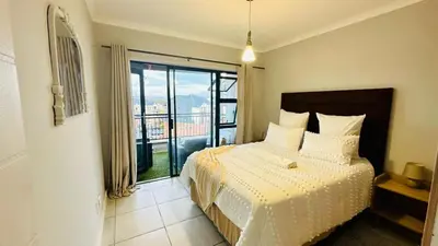a bedroom with a bed with a view of a balcony at House of sebo in Pretoria