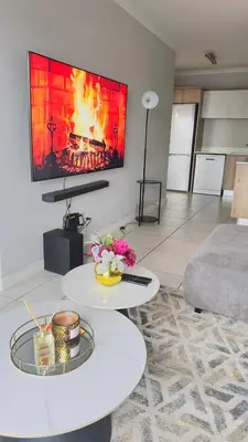 a living room with a fire on the wall at House of sebo in Pretoria