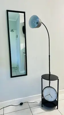 a lamp sitting on a floor next to a mirror at House of sebo in Pretoria