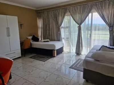 a hotel room with two beds and a large window at AB Lisi Accommodation in Pretoria