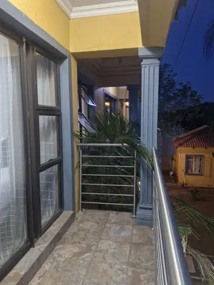 a balcony of a house with windows and a plant at AB Lisi Accommodation in Pretoria