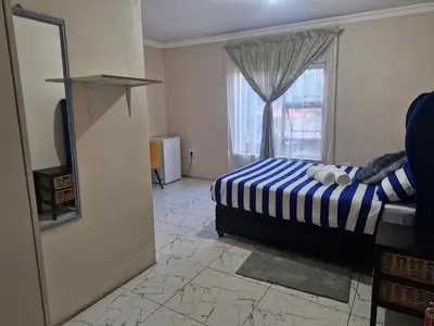 a bedroom with a bed and a window at AB Lisi Accommodation in Pretoria