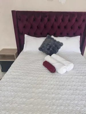 a teddy bear laying on a bed with towels at AB Lisi Accommodation in Pretoria
