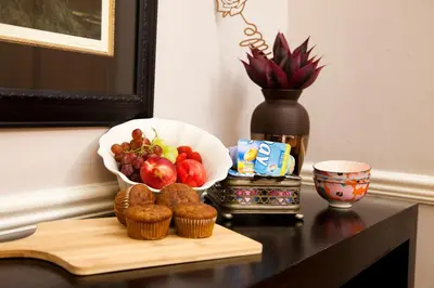 a table with a bowl of fruit and muffins on it at The Gables Middelburg MPU in Middelburg