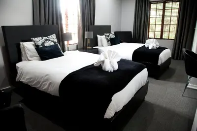 a hotel room with two beds with bows on them at The Gables Middelburg MPU in Middelburg