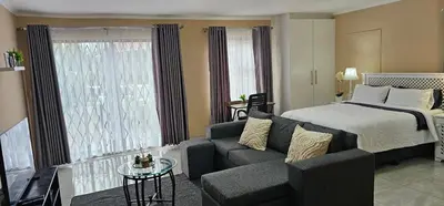 a living room with a bed and a couch at The Luxury stay in Midrand