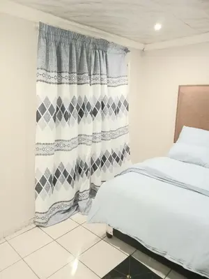 a bedroom with a bed and a shower curtain at Kama house in Pretoria