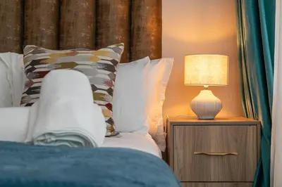 a bedroom with a bed with a lamp on a night stand at The Golden Place in Kempton Park