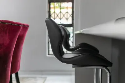 a pair of black chairs sitting next to a counter at The Golden Place in Kempton Park