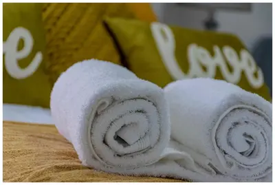 a roll of white towels sitting on a bed at Time out Main in Pretoria
