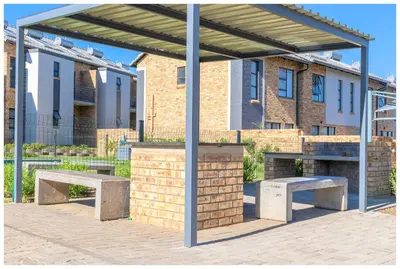 two benches under a pavilion in front of buildings at Time out Main in Pretoria
