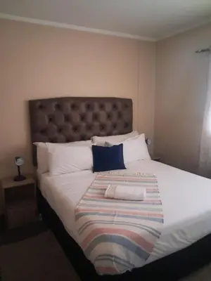 a bedroom with a large bed with a blanket on it at Menlyn Place Oasis in Pretoria
