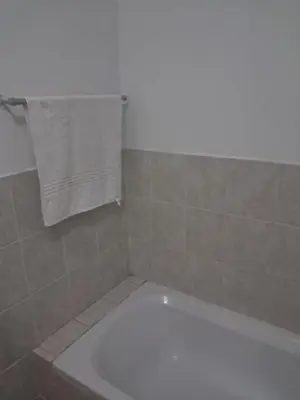a bathroom with a white tub and a white towel at Menlyn Place Oasis in Pretoria