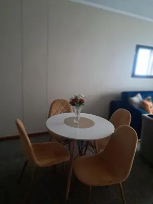a table with chairs and a vase of flowers on it at Menlyn Place Oasis in Pretoria