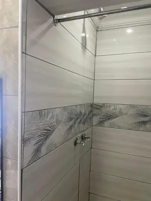a shower with a glass door with a faucet at Bennyz Guest House in Pretoria