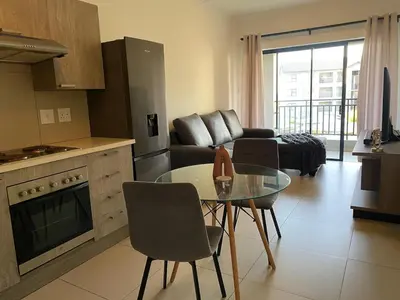a kitchen and a living room with a table and a couch at Where every guest feels special in Midrand