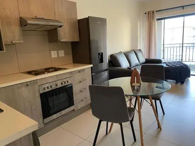 a kitchen and a living room with a table and a couch at Where every guest feels special in Midrand