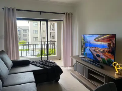a living room with a couch and a flat screen tv at Where every guest feels special in Midrand