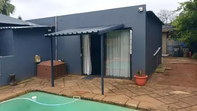 a blue house with a swimming pool in front of it at 329 on 30th Avenue Villieria Jimmy in Pretoria