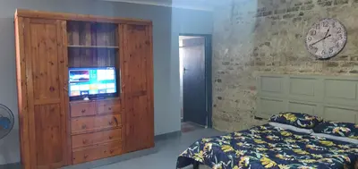 a bedroom with a bed and a dresser with a television at 329 on 30th Avenue Villieria Jimmy in Pretoria