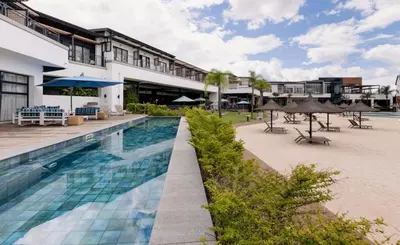 a resort swimming pool with umbrellas and tables at A small haven - The blyde crystal lagoon in Pretoria