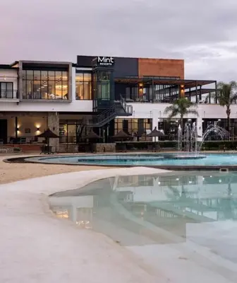 a building with a swimming pool in front of a building at A small haven - The blyde crystal lagoon in Pretoria