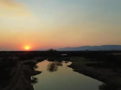 a sunset over a river with the sun setting at Nonaka in Louis Trichardt