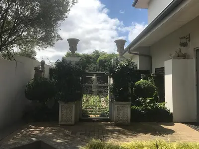 a gate to a house with a statue behind it at AAA Accommodation in Pretoria