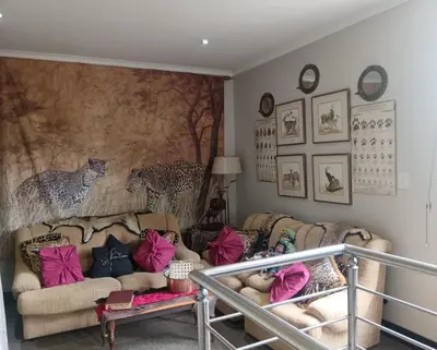 a living room with two couches and a mural at AAA Accommodation in Pretoria