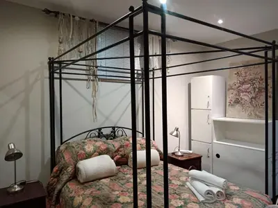 a bedroom with a black bed with a floral bedspread at AAA Accommodation in Pretoria