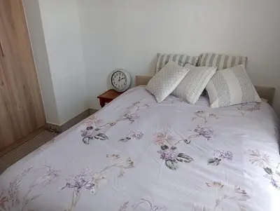 a bedroom with a bed with a clock on the wall at Irene Moo Stay in Pretoria