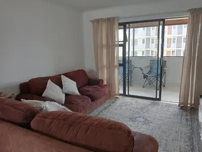 a living room with a couch and a balcony at Irene Moo Stay in Pretoria