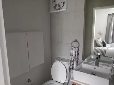 a bathroom with a toilet and a sink and a mirror at Irene Moo Stay in Pretoria