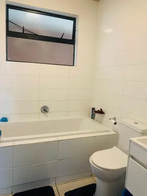 a bathroom with a white tub and a toilet at Luxury Park Stays in Midrand