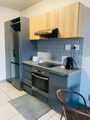 a kitchen with a stove and a refrigerator at Luxury Park Stays in Midrand