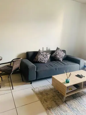 a living room with a blue couch and a coffee table at Luxury Park Stays in Midrand