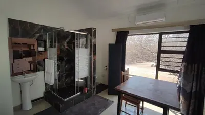 a bathroom with a sink and a toilet and a window at Gemsbokrus in Marloth Park