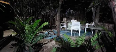 a garden with two white chairs and a table at Gemsbokrus in Marloth Park