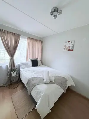 a bedroom with two beds and a window at Charming Hideaway in Sandton