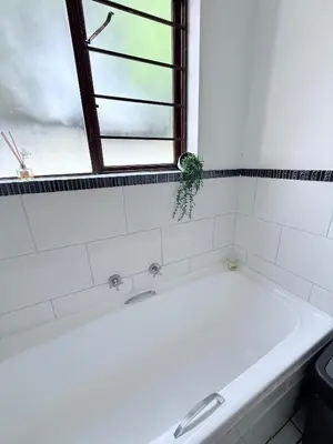 a bath tub in a bathroom with a window at Charming Hideaway in Sandton