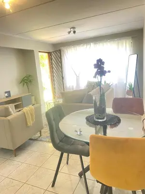 a living room with a table and a couch at Charming Hideaway in Sandton