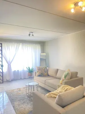 a living room with a couch and a table at Charming Hideaway in Sandton