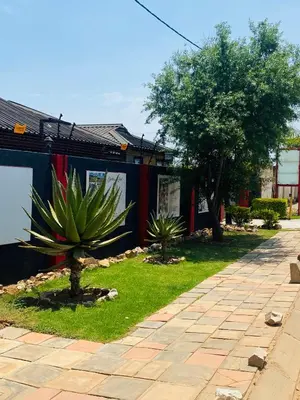 a plant in a yard next to a building at MamSwazi & Bitana Resorts n Restaurants in Pretoria