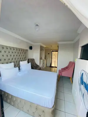 a bedroom with a large white bed in a room at MamSwazi & Bitana Resorts n Restaurants in Pretoria