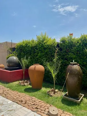 a group of large vases sitting in the grass at MamSwazi & Bitana Resorts n Restaurants in Pretoria