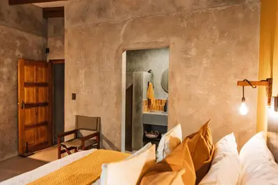 a bedroom with a bed and a wall with a mirror at Chawal Stays Ribbok in Marloth Park